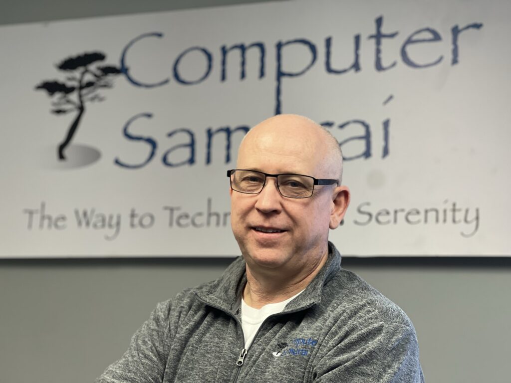 A man in glasses and a shirt is posing for the camera.